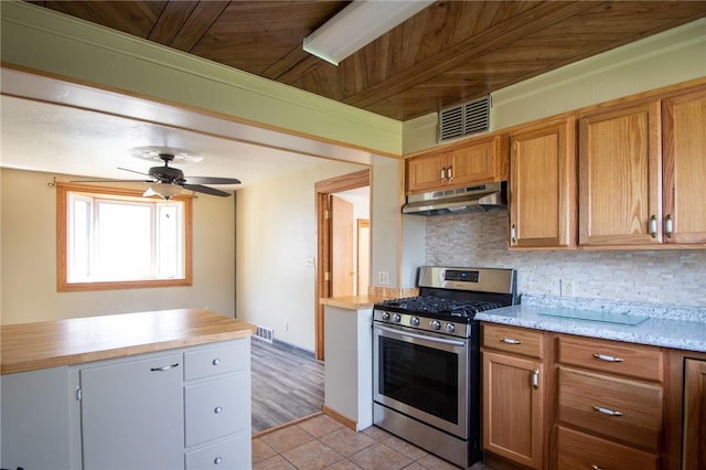 kitchen with backsplash, stainless steel gas stove, ceiling fan, light tile patterned flooring, and wood ceiling