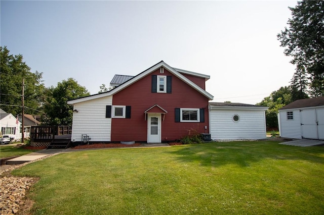 back of house with a lawn, a storage unit, and a wooden deck