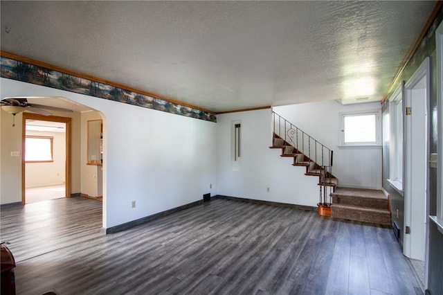 unfurnished living room featuring a wealth of natural light, dark hardwood / wood-style flooring, ceiling fan, and a textured ceiling