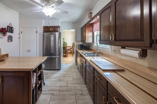 2548 E 32nd St, Erie, PA 16510 - kitchen with freestanding refrigerator, dark brown cabinets, tasteful backsplash, ceiling fan, and butcher block countertops