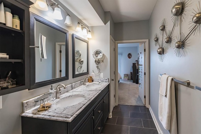 bathroom with double vanity, baseboards, a sink, and tile patterned floors