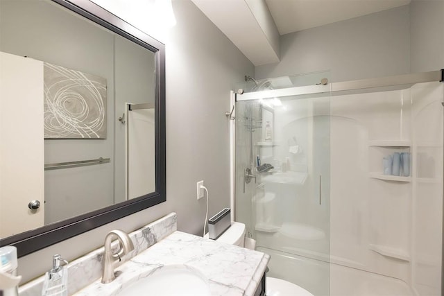 full bathroom featuring a stall shower, vanity, and toilet