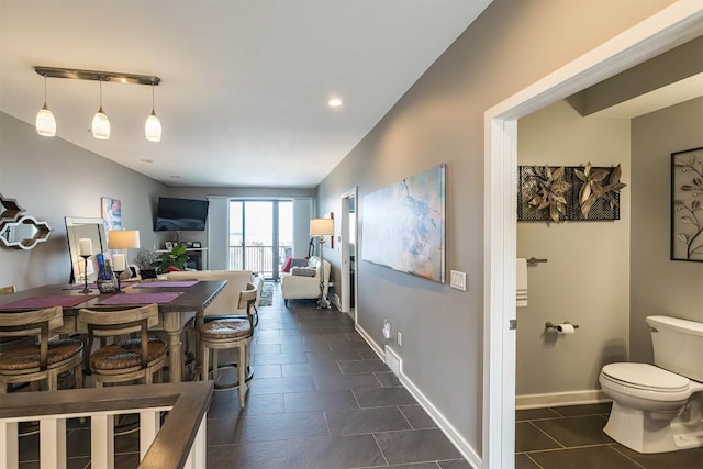 interior space featuring dark tile patterned flooring and baseboards