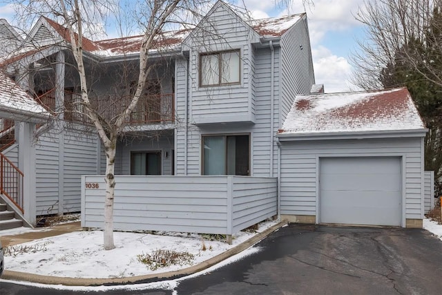 view of front of home with a garage, driveway, and a shingled roof