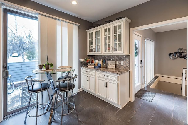 bar featuring decorative backsplash and dark tile patterned flooring