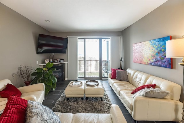 living room featuring a glass covered fireplace and tile patterned floors