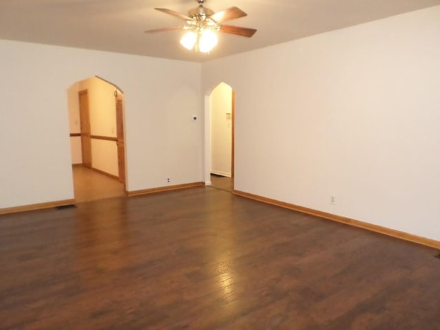 empty room featuring ceiling fan and dark hardwood / wood-style flooring