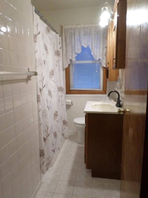 bathroom with tile walls, vanity, a shower with curtain, tile patterned floors, and toilet