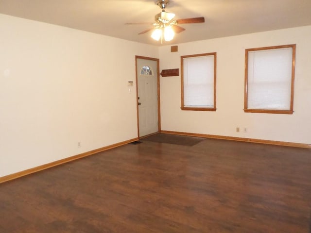 unfurnished room featuring dark wood-type flooring and ceiling fan