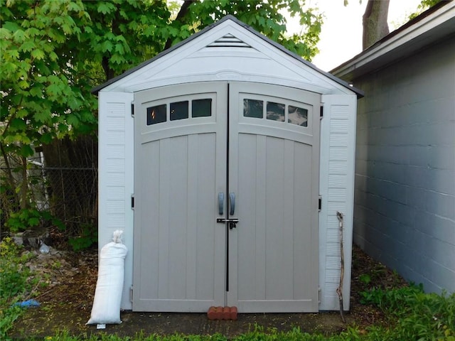 view of shed featuring fence