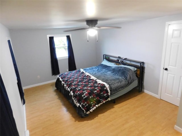 bedroom with light wood finished floors, baseboards, and ceiling fan