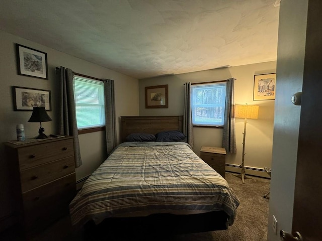 bedroom with baseboard heating and carpet floors