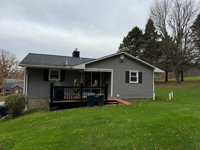 rear view of house featuring a yard and a wooden deck