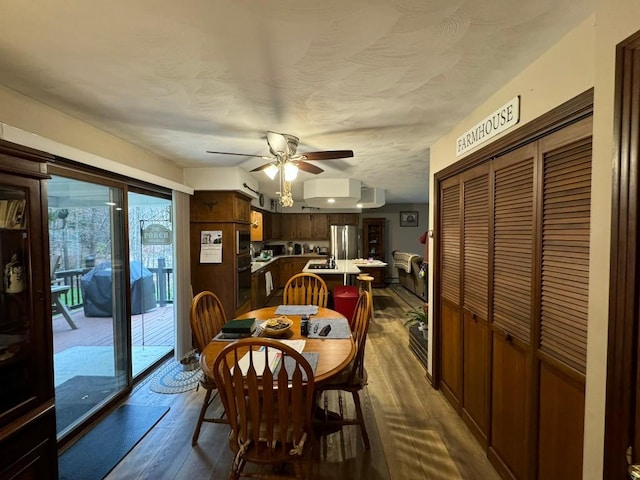 dining space featuring ceiling fan and dark wood-type flooring