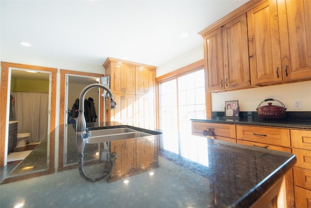 kitchen featuring sink and dark stone countertops