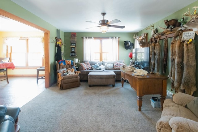 living room with ceiling fan and light colored carpet