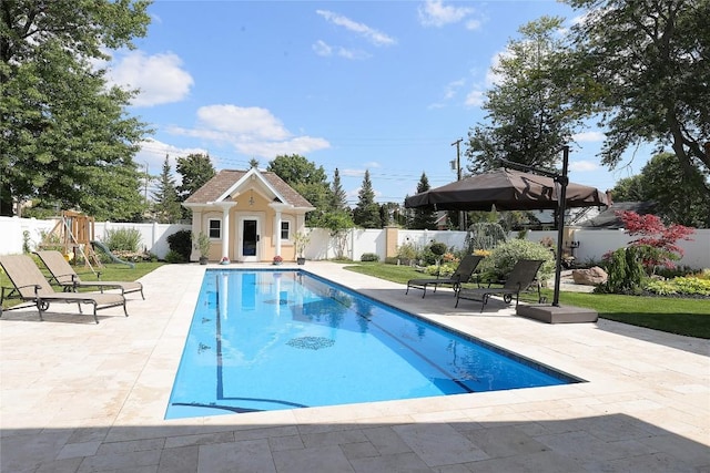 view of swimming pool featuring an outbuilding and a patio