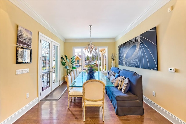 dining area with french doors, an inviting chandelier, dark wood-type flooring, and ornamental molding