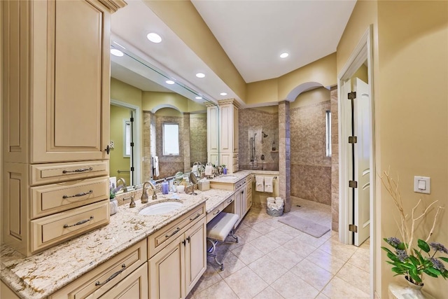 bathroom featuring tile patterned flooring, vanity, and tiled shower