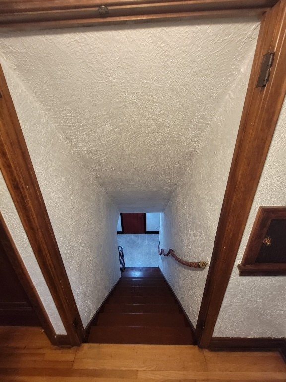 stairway featuring hardwood / wood-style flooring and a textured ceiling