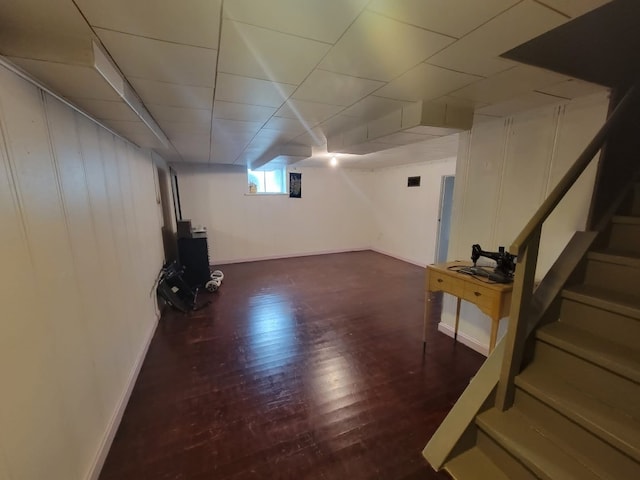 basement with dark hardwood / wood-style floors