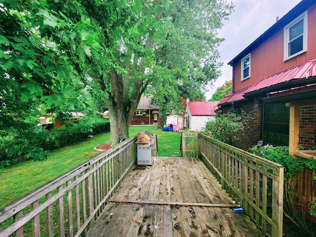 wooden terrace featuring a lawn