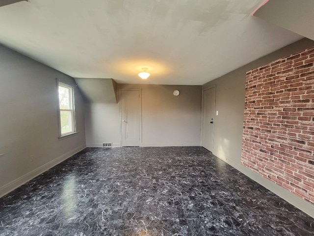 unfurnished room with brick wall