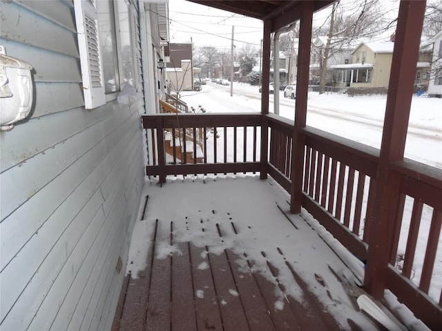 snow covered deck featuring covered porch