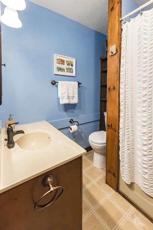 bathroom with vanity, a textured ceiling, and toilet