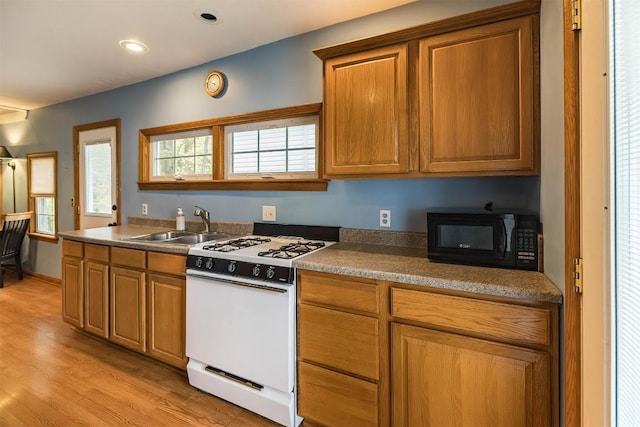 kitchen featuring gas range gas stove, sink, and light hardwood / wood-style flooring