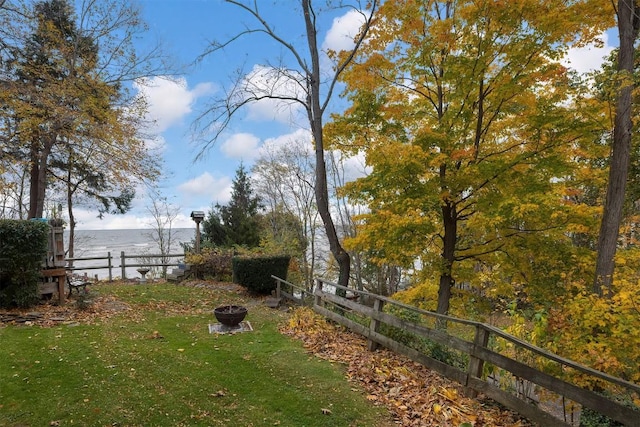 view of yard featuring a water view and a fire pit