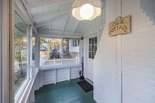 sunroom / solarium featuring vaulted ceiling with beams and a wealth of natural light