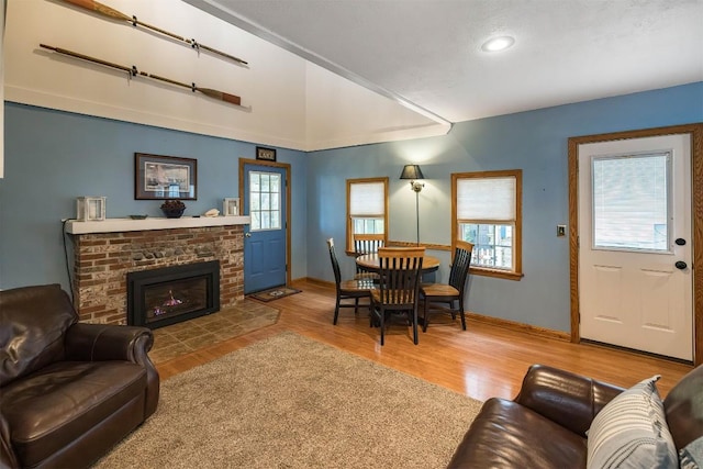 living room with hardwood / wood-style flooring and a brick fireplace