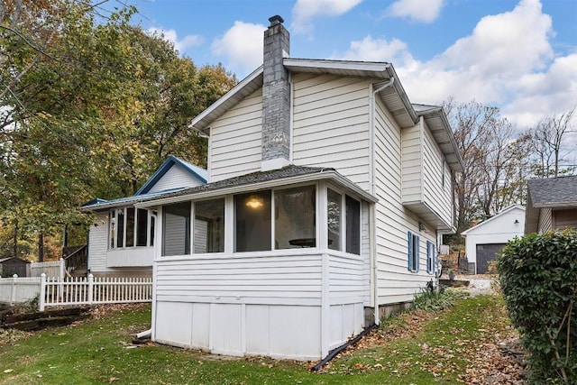 view of home's exterior with a yard and a sunroom