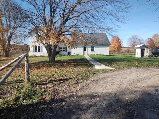 view of front of property featuring a storage shed and a front yard