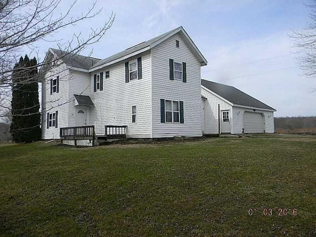 rear view of property with a garage and a yard