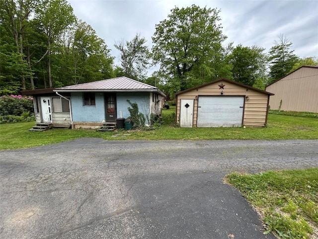 2892 Township Rd, Linesville, PA 16424 - view of front of home featuring an outdoor structure, a detached garage, a front yard, metal roof, and entry steps