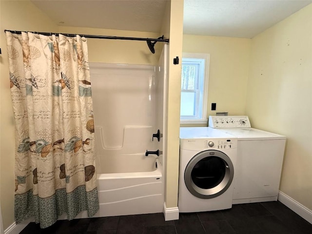 clothes washing area featuring baseboards, washer / clothes dryer, laundry area, and dark tile patterned flooring