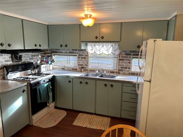 kitchen with green cabinets, sink, and white appliances