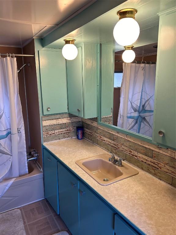 bathroom with backsplash, shower / tub combo with curtain, and vanity