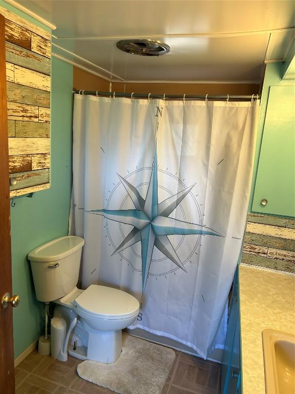 bathroom featuring a shower with curtain, toilet, and sink