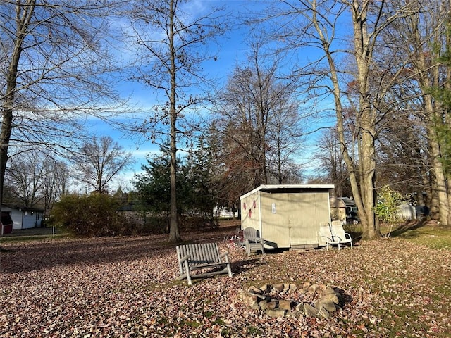 view of yard featuring a fire pit and a storage shed