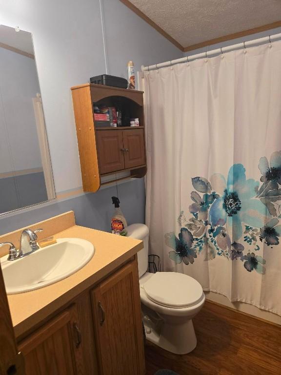 2719 Green Hill Dr, Millcreek, PA 16506 - full bath featuring vanity, crown molding, wood finished floors, a textured ceiling, and a shower with shower curtain