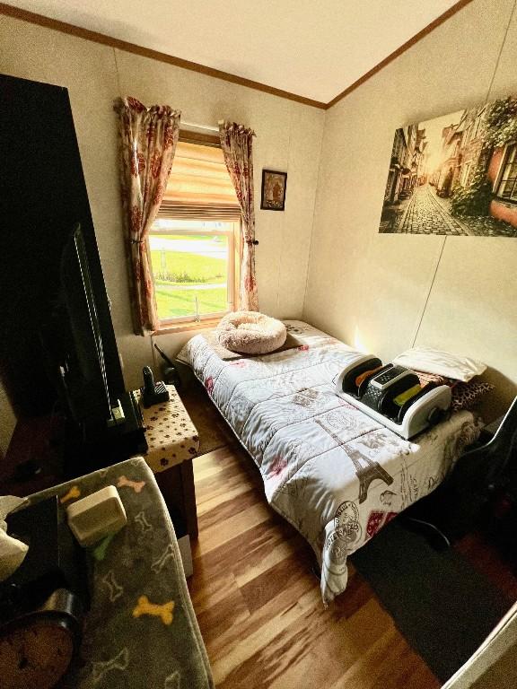 bedroom featuring hardwood / wood-style flooring and crown molding