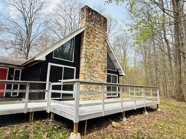 rear view of property with a deck and a chimney