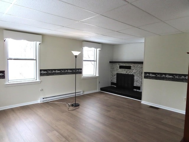 12322 N Watson Run Rd, Conneaut Lake, PA 16316 - unfurnished living room featuring wood finished floors, a fireplace with raised hearth, baseboards, and a baseboard heating unit