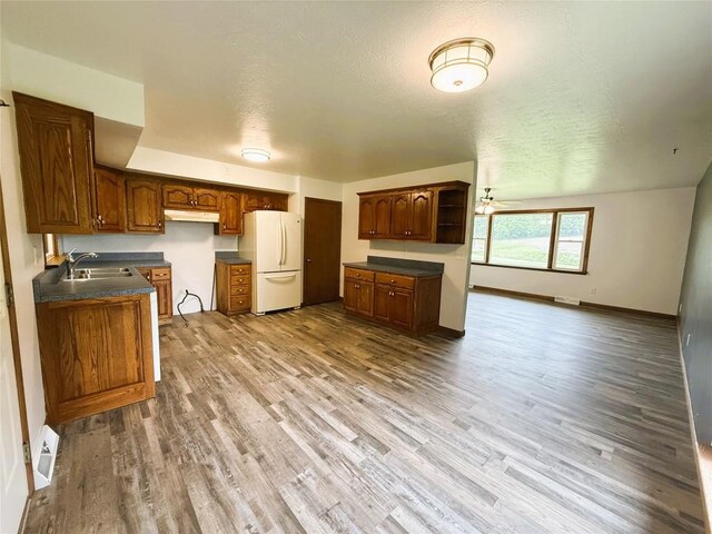 31050 US Highway 322, Cochranton, PA 16314 - kitchen featuring freestanding refrigerator, a sink, dark countertops, under cabinet range hood, and wood finished floors