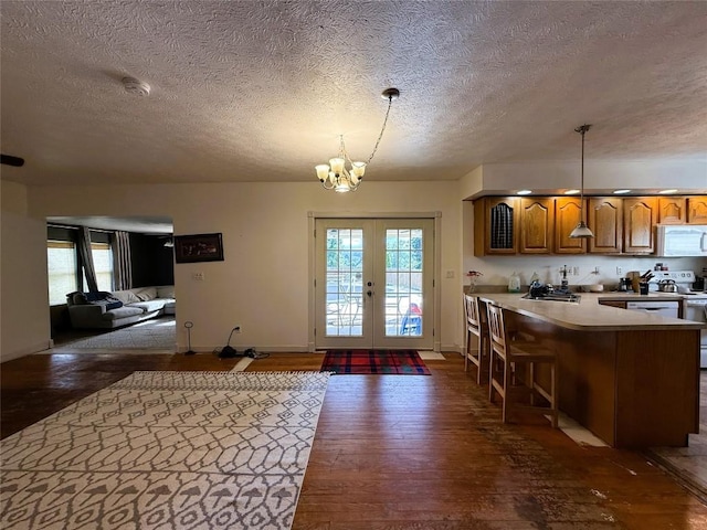 10537 Franklin Pike, Meadville, PA 16335 - kitchen with white microwave, a textured ceiling, dark wood-type flooring, brown cabinetry, and a chandelier