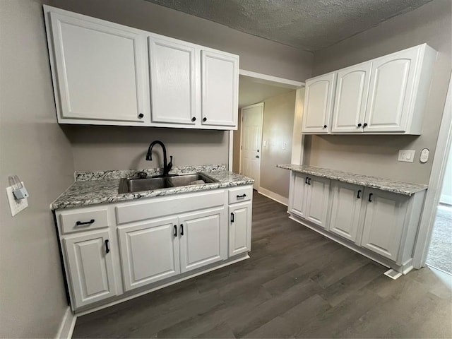 917 Walnut St, Erie, PA 16502 - kitchen with a sink, dark wood-style flooring, white cabinets, a textured ceiling, and baseboards