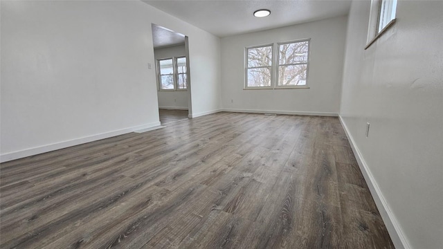 empty room with dark hardwood / wood-style flooring